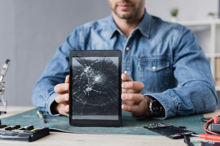 Repairman showing smashed iPad tablet for repair
